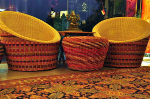 A stunning rattan pendant light fixture hanging above a wooden coffee table displayed in the shop.