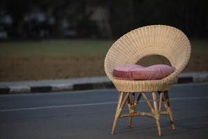 A traditional wooden bed frame with rattan accents displayed in the furniture store.